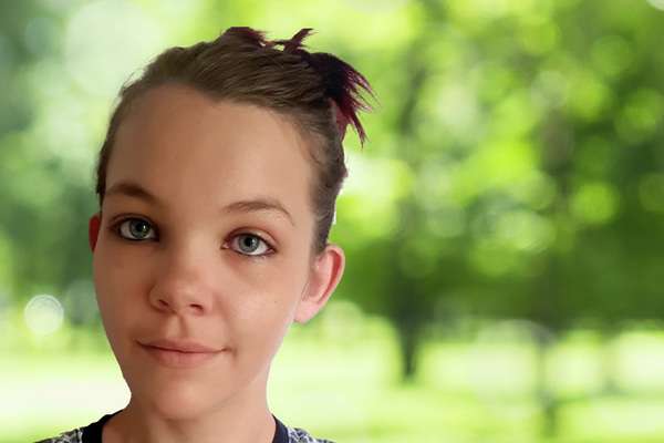 Kristie Huntly smiling with a blurry treescape background