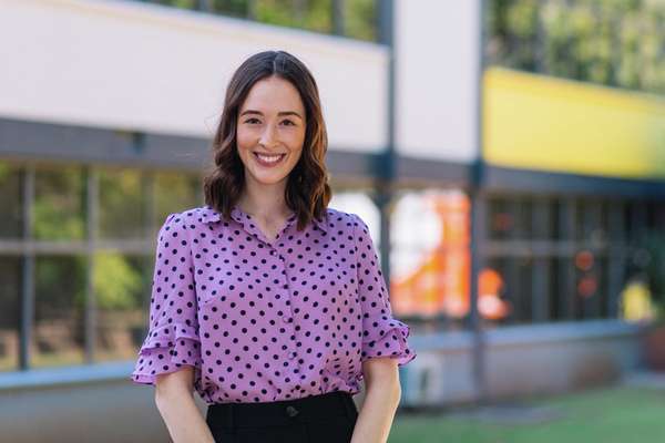 Shaye Byrne standing outside the Rockhampton engineering building smiling at the camera
